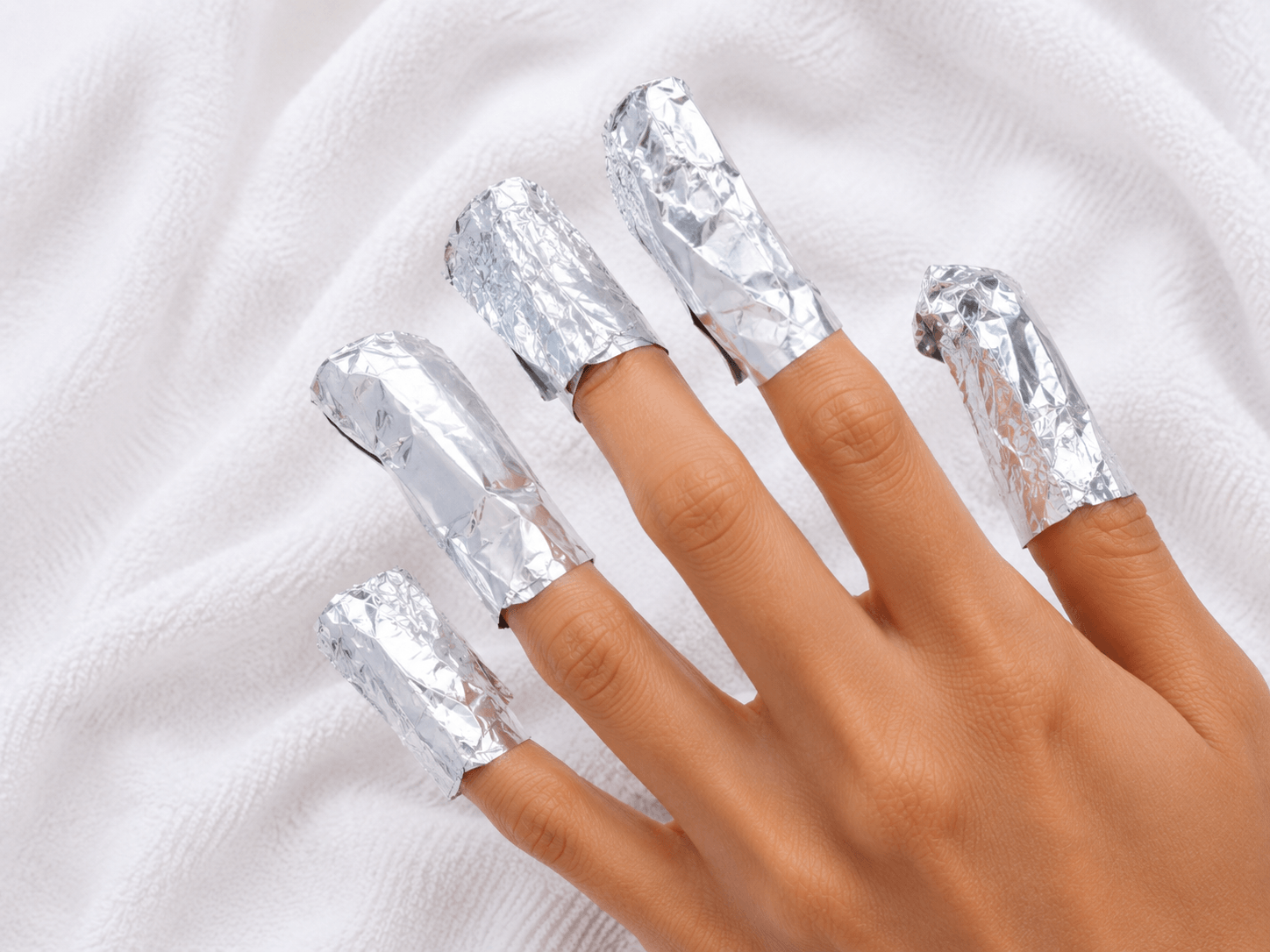 All five fingertips wrapped in aluminium foil to soak off gel nail polish at home