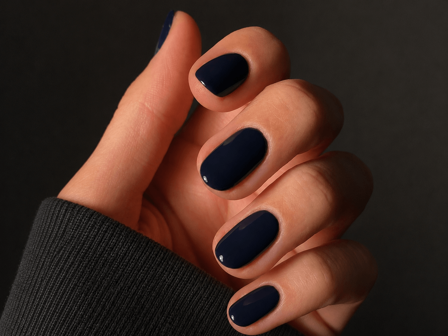 Short navy blue gel nails with glossy finish on natural nails
